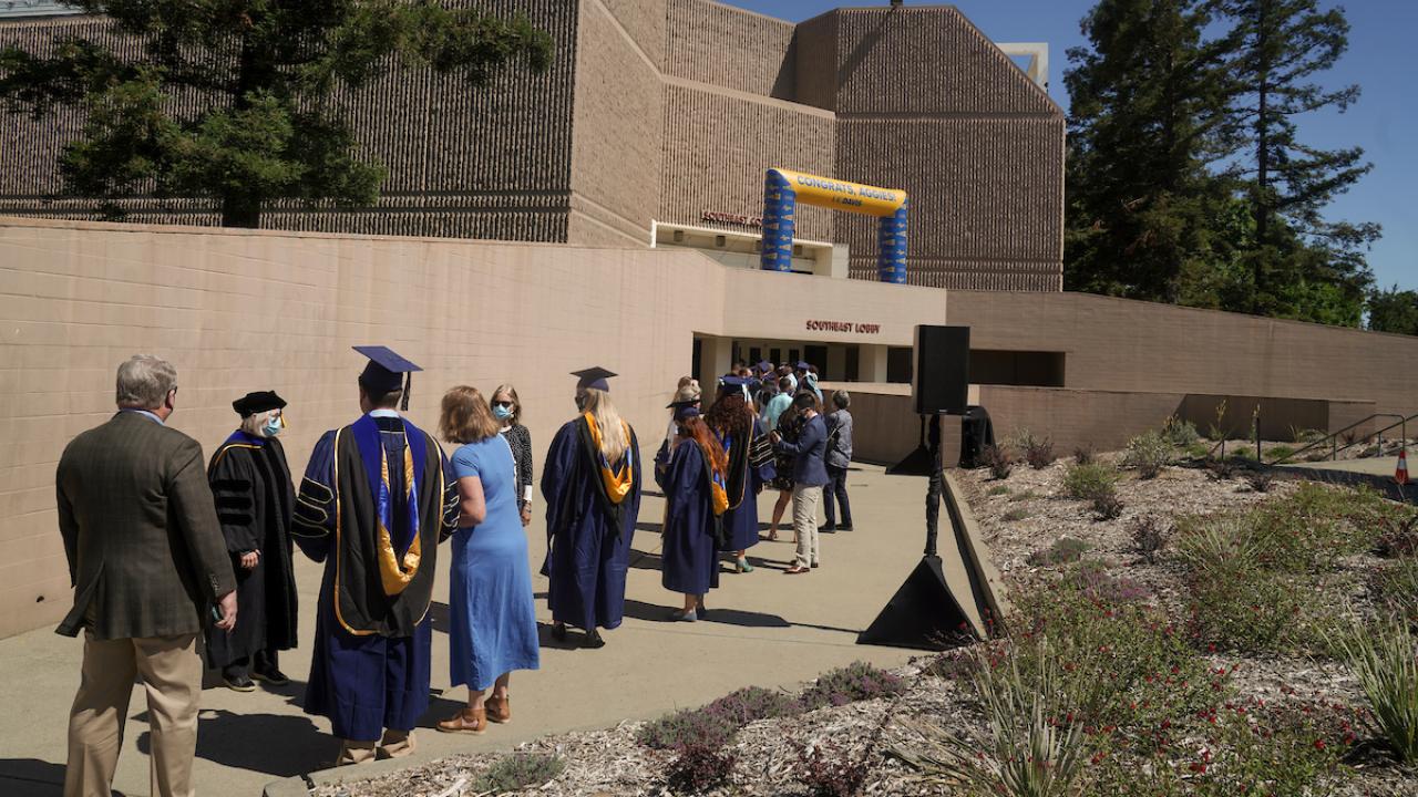 people stand in line for graduation ceremony