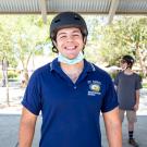 Student poses wearing a helmet and mask.